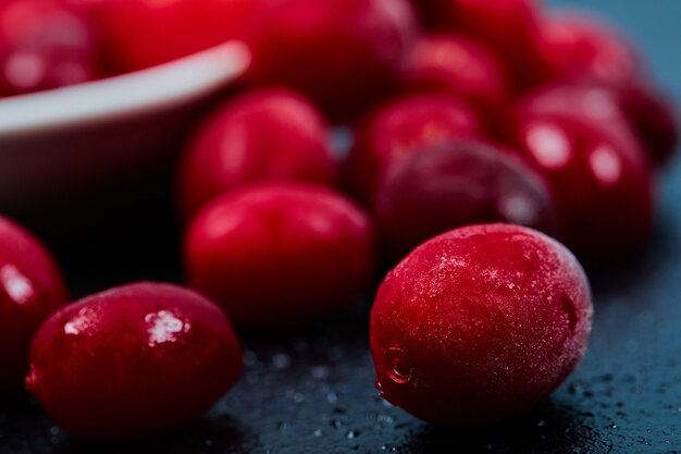 Reife Kornelkirschenbeeren auf dunklem Tisch. Nahansicht.