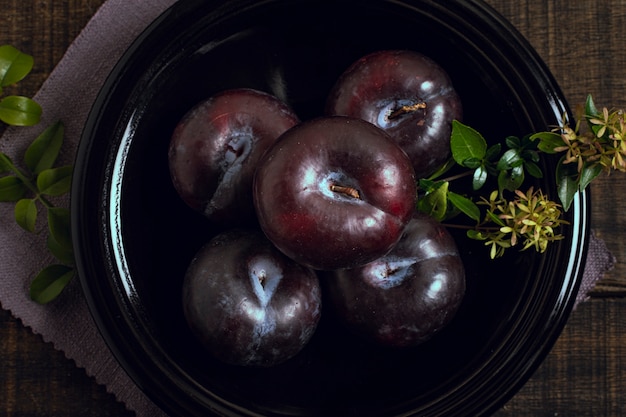 Kostenloses Foto reife pflaumenfrucht der nahaufnahme in einer schüssel