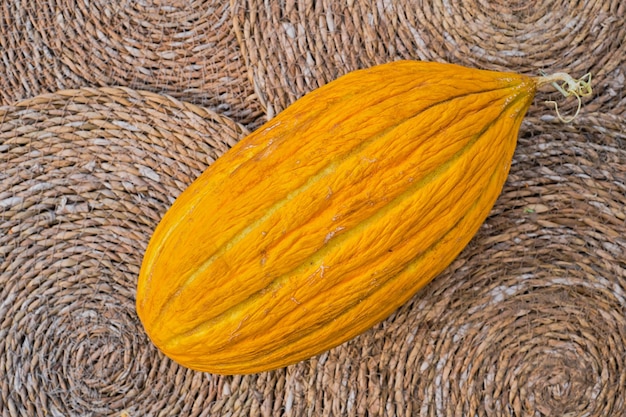 Reife saftige gelbe türkische Melone auf Stroh ausgekleidet Draufsicht Bio-Obst-Werbeidee vom Bauernmarkt Konzept für Hintergrund oder Artikel