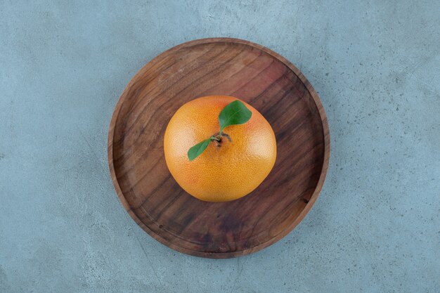 Reife saftige Orange auf einer Holzplatte, auf dem Marmorhintergrund. Foto in hoher Qualität