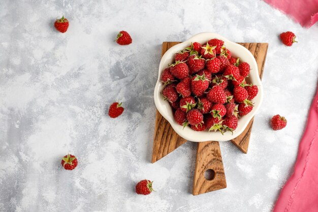 Reife süße Himbeeren in der keramischen Platte auf grauem Beton. Nahaufnahme, Ansicht von oben