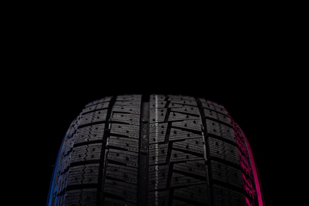 Reifen mit profil zum fahren auf eis und schnee auf schwarzem hintergrund mit einem bild blau-rot Premium Fotos
