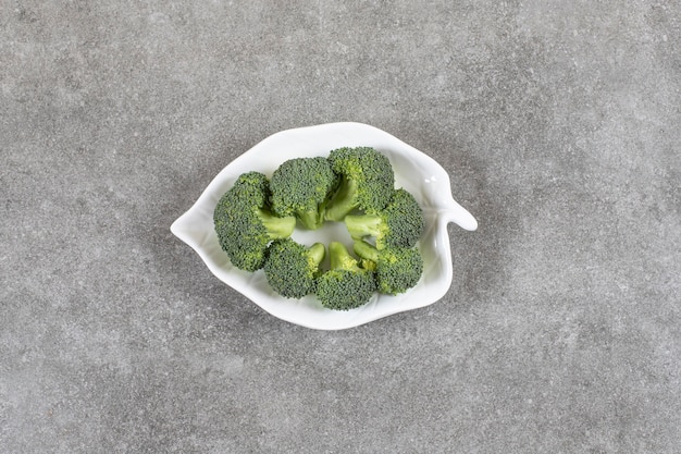 Reifer Brokkoli auf einem Teller auf dem Marmortisch.