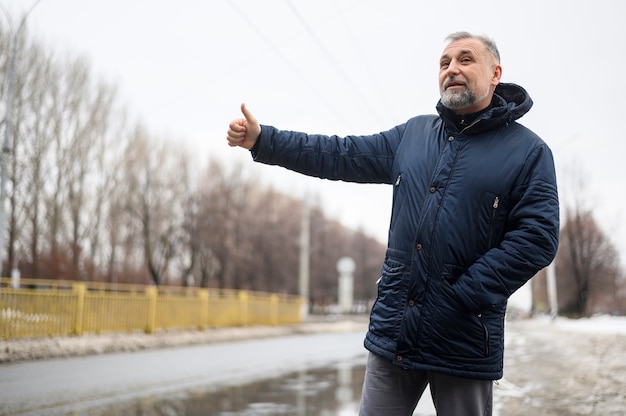 Kostenloses Foto reifer mann, der eine fahrt sucht