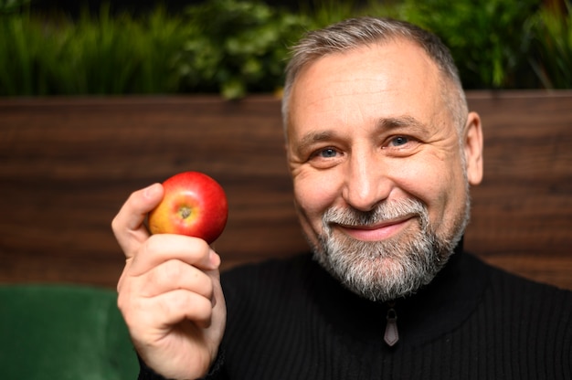 Reifer Mann, der einen Apfel hält