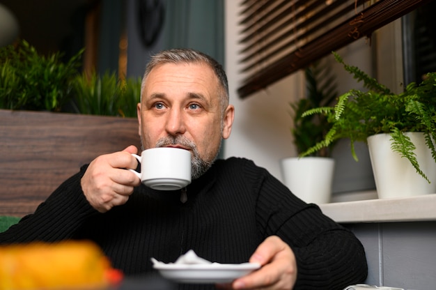 Kostenloses Foto reifer mann, der kaffee trinkt