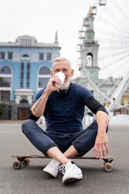 Kostenloses Foto reifer mann mit nachhaltigem mobilitätsskateboard