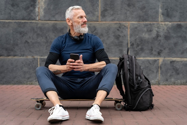 Kostenloses Foto reifer mann mit nachhaltigem mobilitätsskateboard