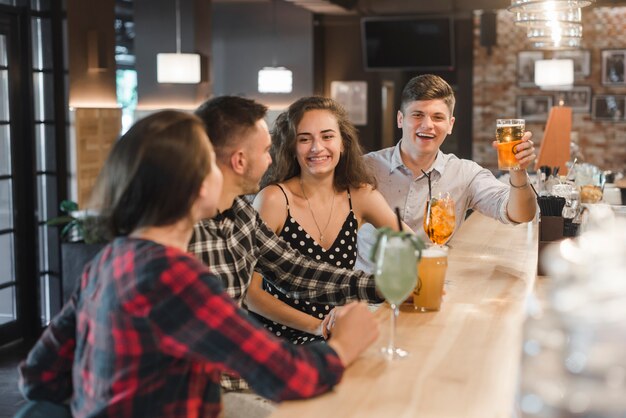 Reihe der Freunde, die Getränke in der Kneipe genießen