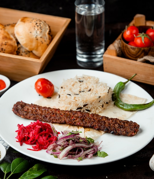 Reis mit Fleisch, Zwiebeln und einem Glas Wasser