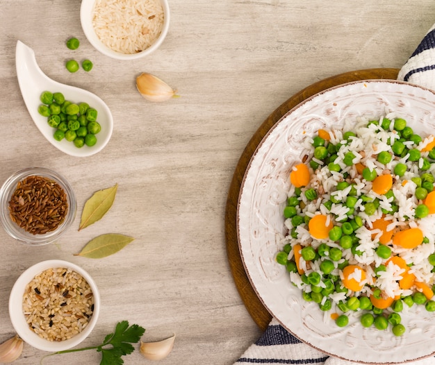 Reis mit grünen Bohnen und Karotte auf Platte mit Schüsseln