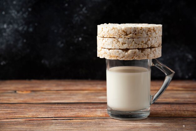 Reiscracker und Glas Milch auf Holztisch.