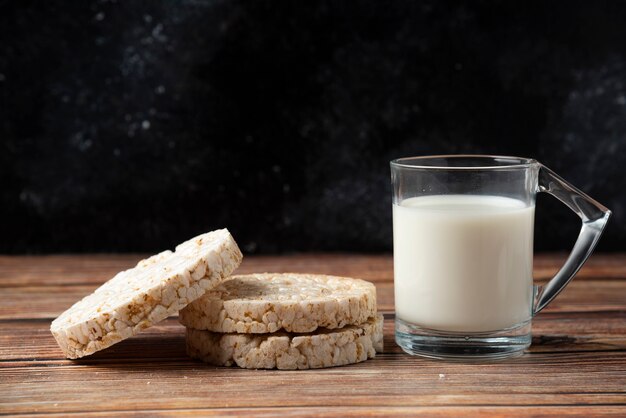 Reiscracker und Glas Milch auf Holztisch.