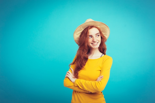 Reise-Konzept - Nahaufnahme Porträt junge schöne attraktive Redhair Mädchen mit trendy Hut und Sonnenbrille lächelnd. Blauer Pastellhintergrund. Platz kopieren