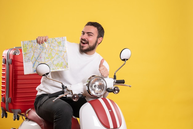 Reisekonzept mit lächelndem Kerl, der auf einem Motorrad mit Koffer darauf sitzt und die Karte zeigt, die eine ok Geste auf Gelb macht