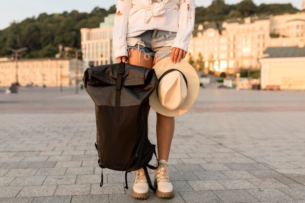 Reisende Frau, die mit Hut und Rucksack aufwirft