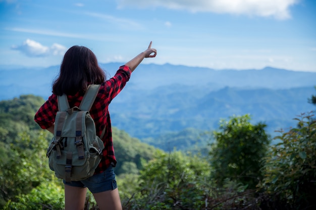 Reisende, junge Frauen, schauen sich die erstaunlichen Berge und Wälder an, lassen sich von Reiselust inspirieren,