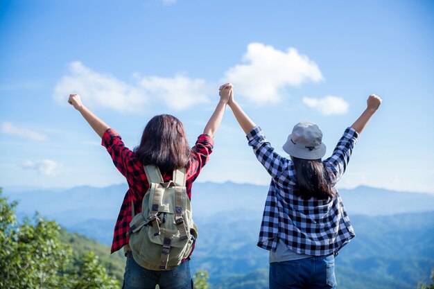 Reisende, junge Frauen, schauen sich die erstaunlichen Berge und Wälder an, lassen sich von Reiselust inspirieren,