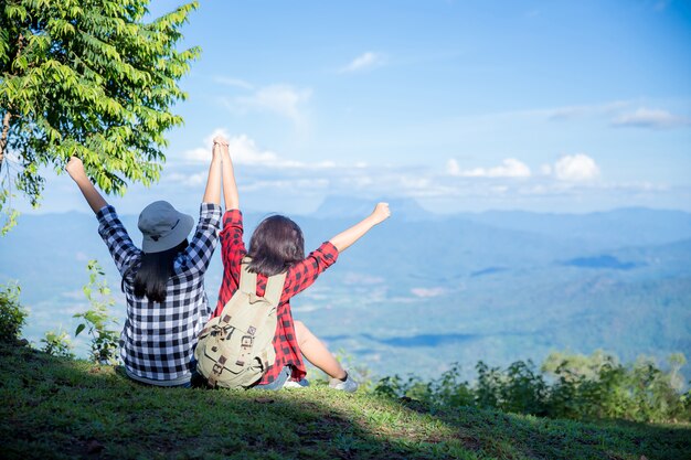 Reisende, junge Frauen, schauen sich die erstaunlichen Berge und Wälder an, lassen sich von Reiselust inspirieren,