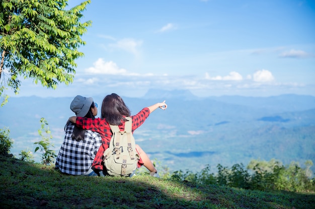 Reisende, junge Frauen, schauen sich die erstaunlichen Berge und Wälder an, lassen sich von Reiselust inspirieren,