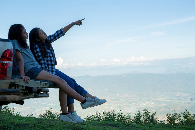 Reisende, junge Frauen, schauen sich die erstaunlichen Berge und Wälder an, lassen sich von Reiselust inspirieren,