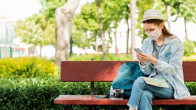 Reisender, der medizinische Maske im Park trägt