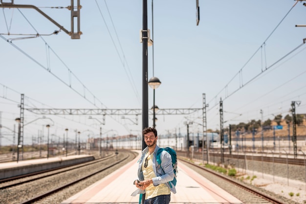 Reisender, der nach Zug auf Stationsplattform sucht
