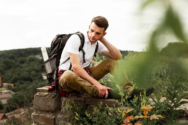 Reisender mit Rucksack, der auf Felsen ruht