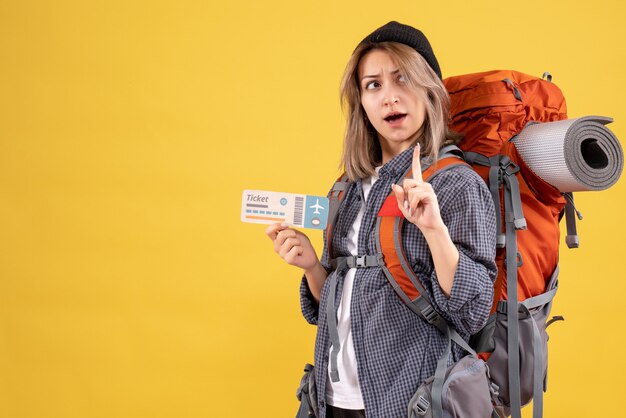 Reisendes Mädchen mit Rucksack mit Flugticket überraschend mit einer Idee