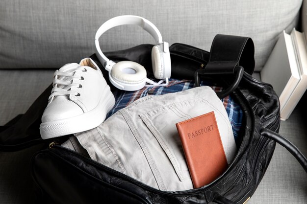 Reisetasche mit Turnschuhen und Brieftasche in der Hose