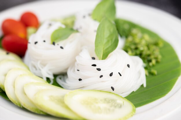 Reisnudeln in einem Bananenblatt mit schön gelegtem Gemüse und Beilagen. Thai Essen.