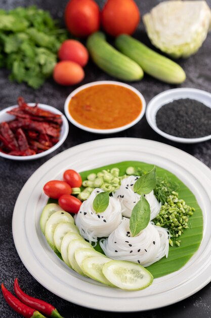 Reisnudeln in einem Bananenblatt mit schön gelegtem Gemüse und Beilagen. Thai Essen.