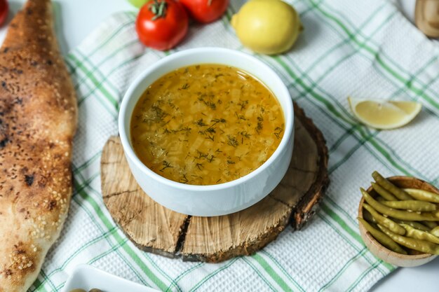 Reissuppe in der Schüssel auf dem Holzbrett mit Gemüse