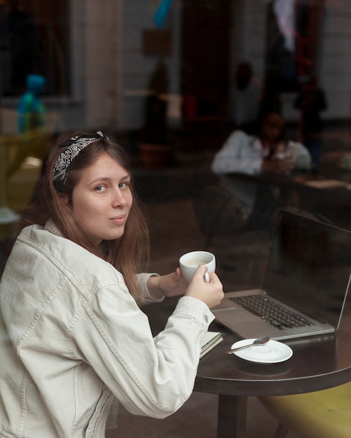 Reizende Frau, die Kaffeetasse hält