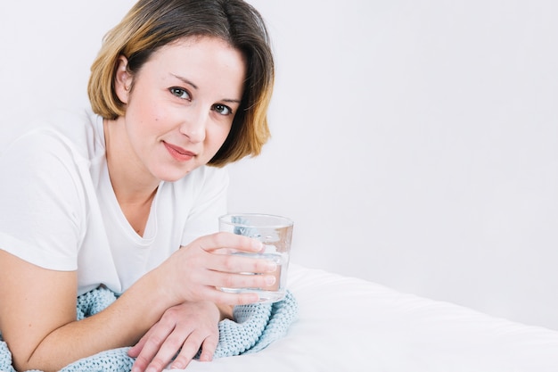 Kostenloses Foto reizende frau mit wasser, das auf bett liegt