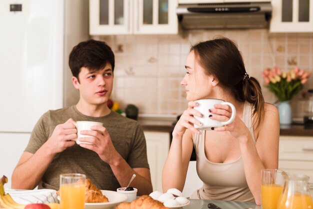 Reizende junge Paare, die zusammen frühstücken