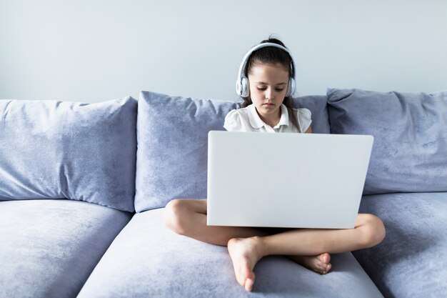 Reizende kleine Mädchen, die ihren Laptop verwenden