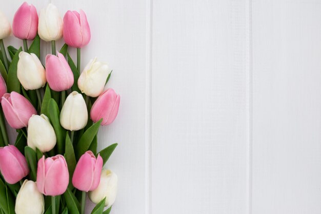 Reizender Blumenstrauß von Tulpen auf weißem hölzernem Hintergrund mit copyspace rechts