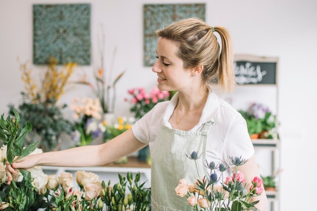 Reizender Florist, der Blumenstrauß macht