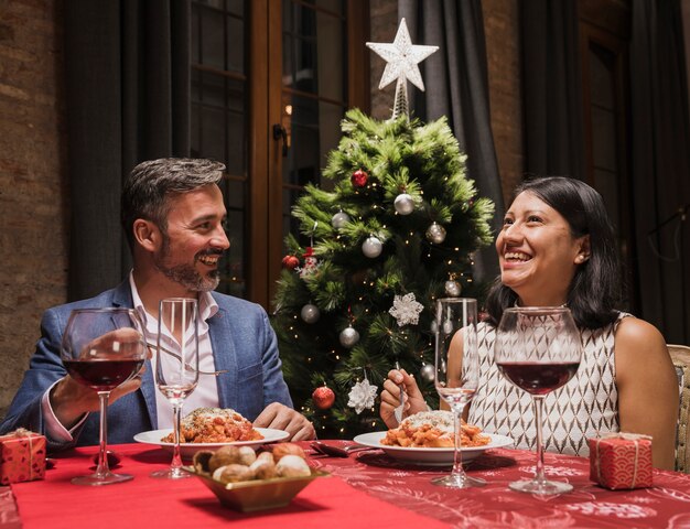 Reizender Mann und Frau am Weihnachtsabendessen