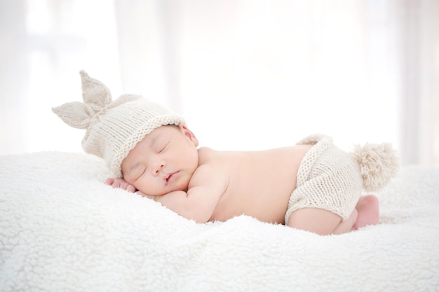 Reizendes neugeborenes asiatisches Baby, das auf pelzigem Stoff schläft
