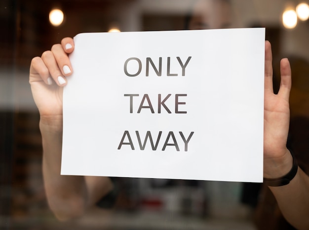 Restaurantangestellter, der ein Takeaway-Schild vor das Restaurant stellt?