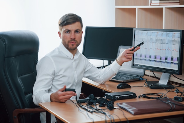 Resuts werden morgen sein. Der Polygraph-Prüfer arbeitet im Büro mit der Ausrüstung seines Lügendetektors