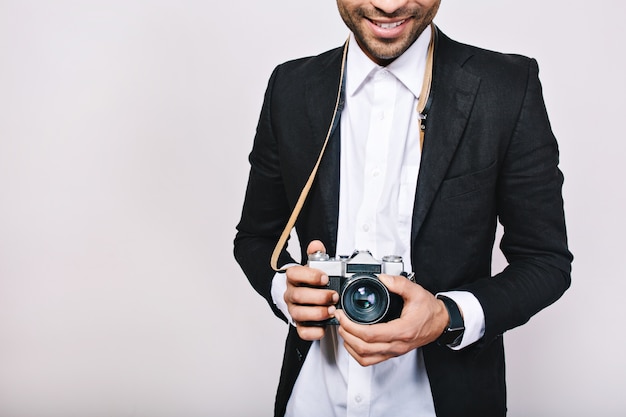 Retro-Kamera in den Händen des gutaussehenden Kerls im Anzug. Freizeit, Reisen, Journalist, Foto, Hobbys, Lächeln, Spaß haben.