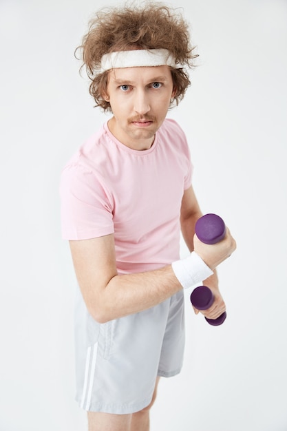 Retro mann im rosa t-shirt und in den grauen sportshorts