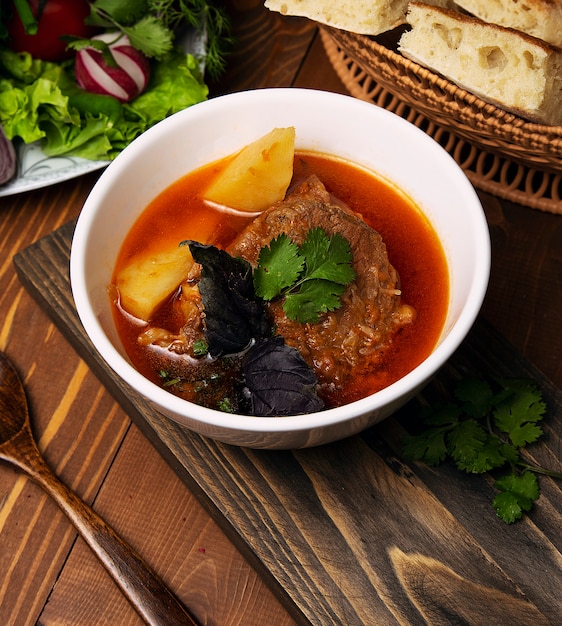 Rindfleisch-Lamm-Eintopf-Bosbash-Suppe mit Kartoffeln, Basilikum und Petersilie in Tomatensauce.