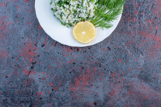 Risotto mit Kräutern und einer Zitronenscheibe.