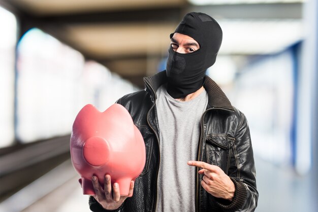 Robber hält ein Sparschwein