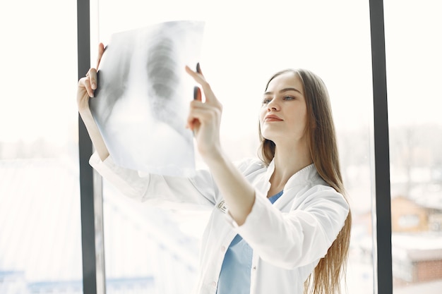 Röntgen am Fenster. Frau mit langen Haaren. Doktor in Arbeitskleidung.