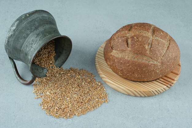 Roggenbrötchen auf Holzbrett mit Becher Gerste